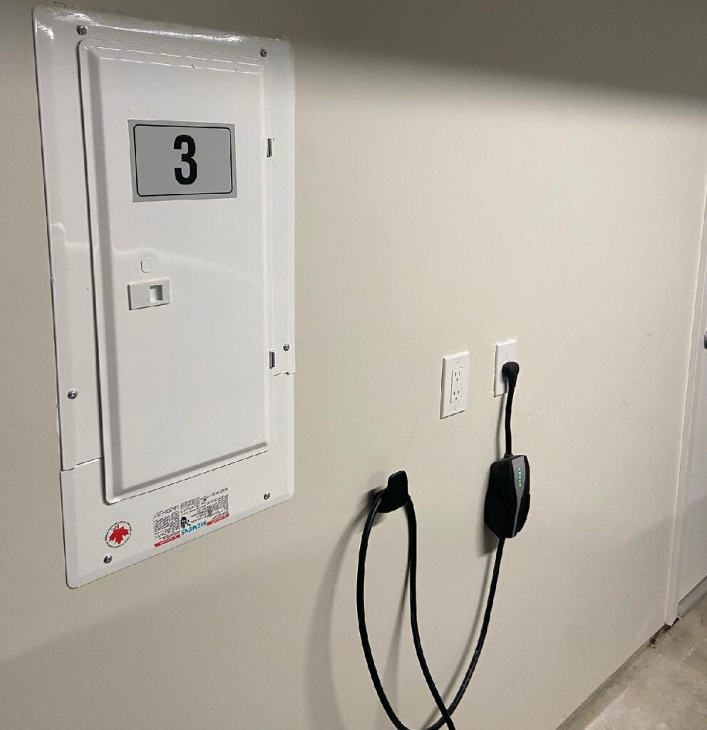 Standard Level 1 EV charging cable plugged into a 120V household outlet in a home garage.