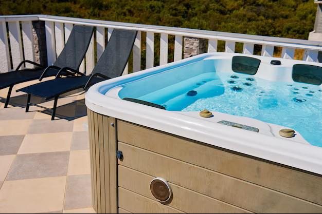 A luxury outdoor hot tub on a deck, which requires a dedicated circuit and significant electrical service capacity to operate safely.