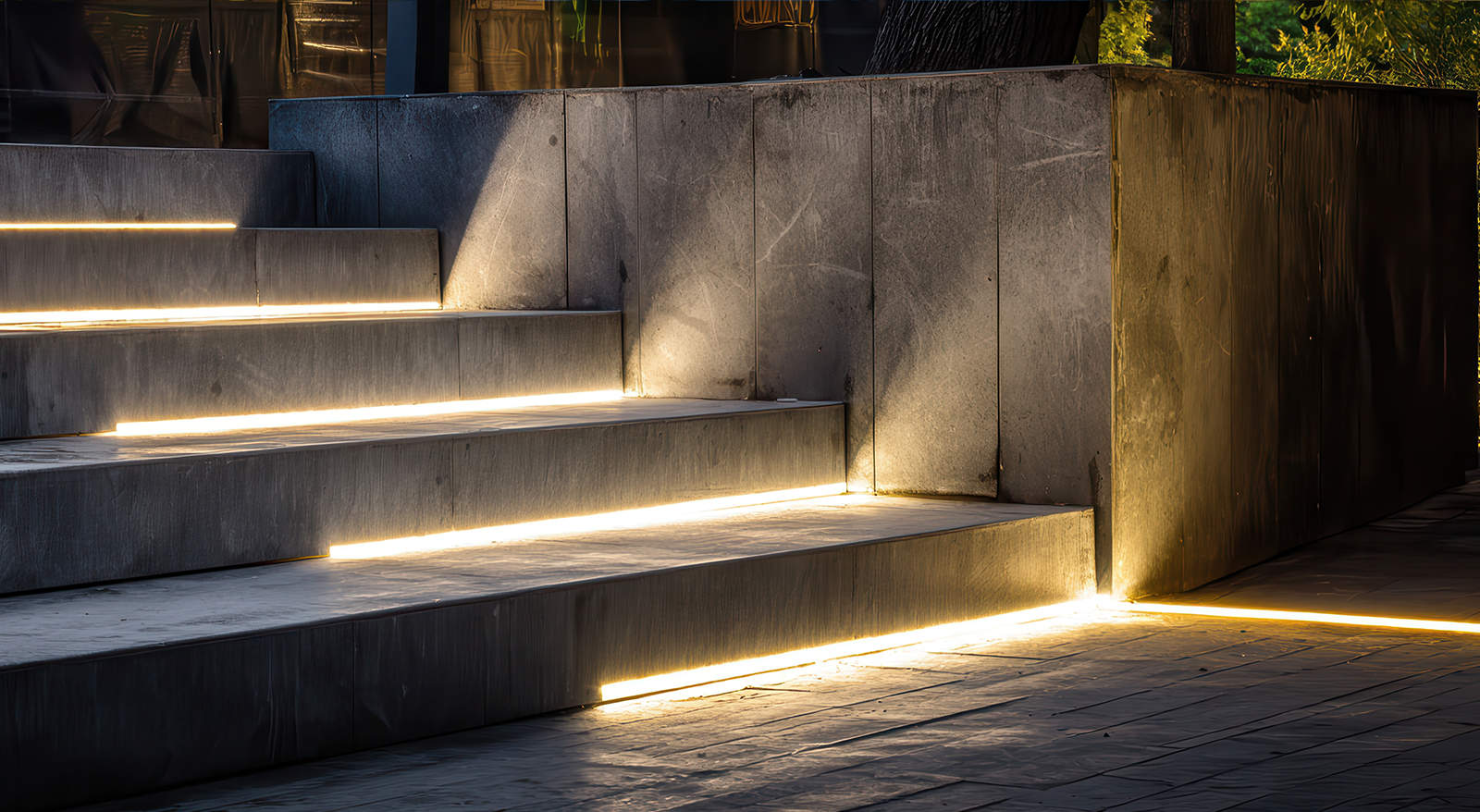 Modern low-profile LED strip lights installed under stone outdoor steps for improved nighttime safety and visibility.